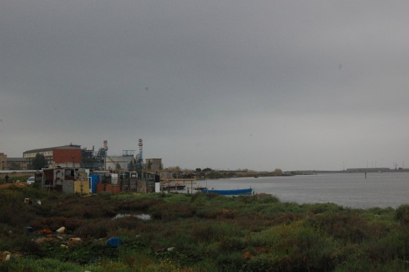 Cagliari, S. Gilla, , presenza di baracche in metallo, legname ed eternit. Sullo sfondo la centrale ENEL